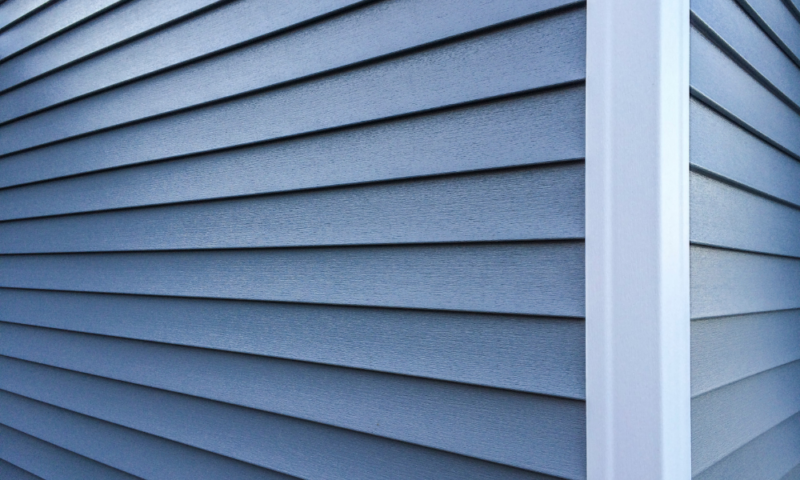 Close-up of blue vinyl siding installed by Wolf River Construction, showcasing quality and durable exterior solutions