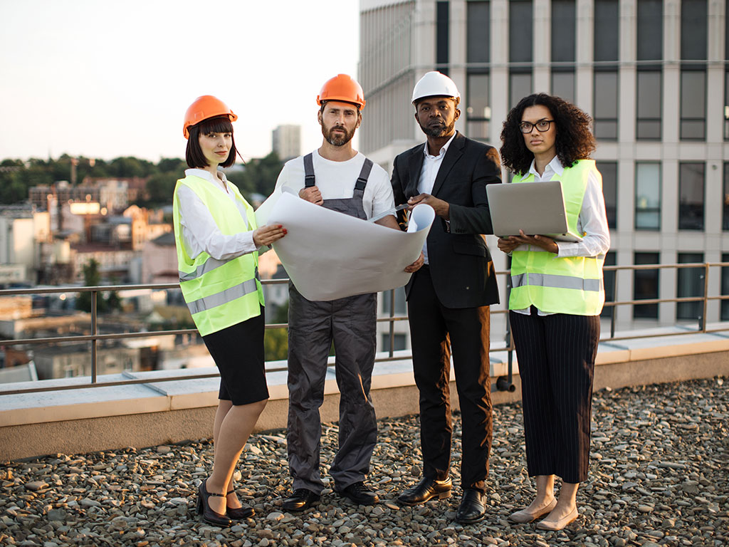 Team of construction professionals reviewing plans on a rooftop, representing Wolf River Construction's expertise in commercial projects.