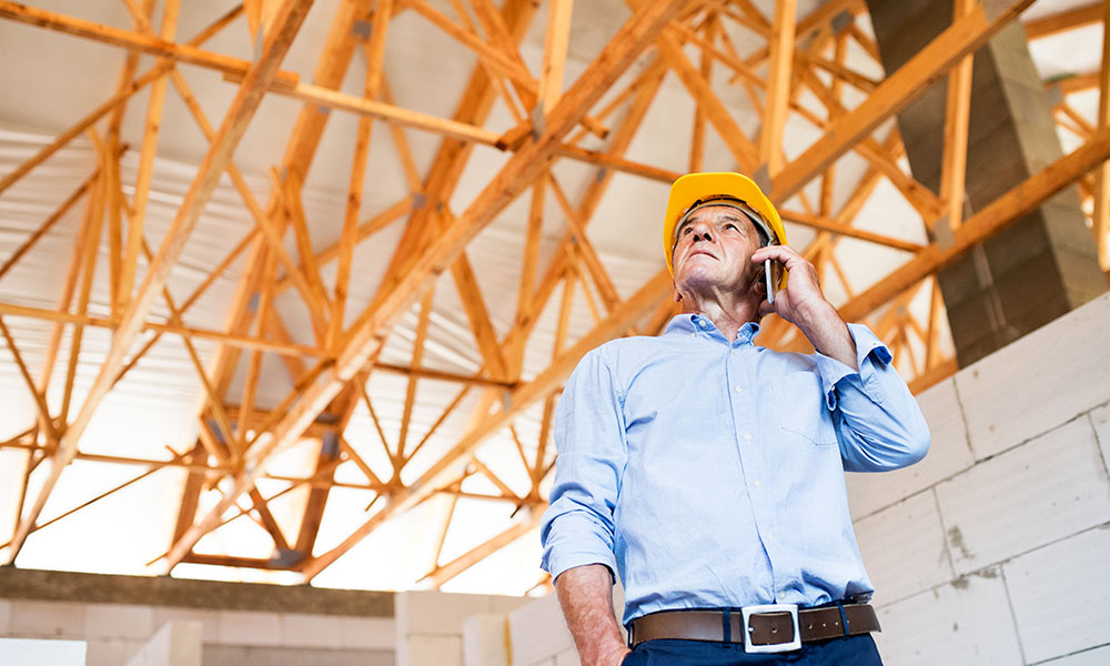 Construction inspector assessing roofing framework at a Wolf River Construction project site, ensuring quality and structural integrity.