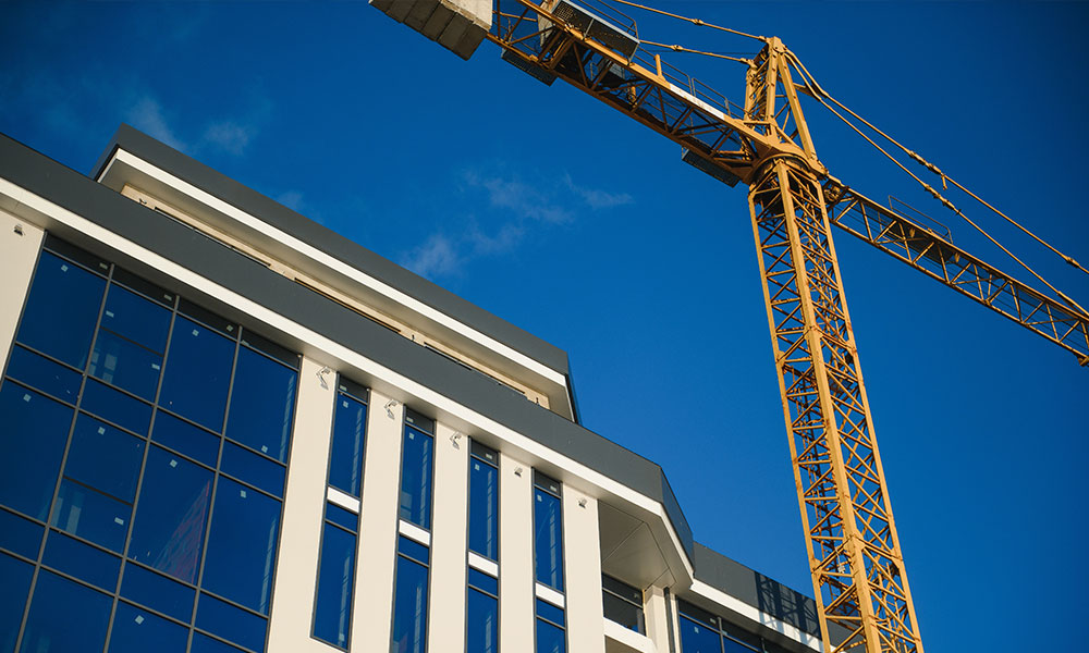 Modern commercial building under construction with a crane, a Wolf River Construction project showcasing quality and precision.