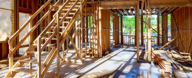 Interior view of a construction site showcasing wooden framework and stairs, highlighting Wolf River Construction's craftsmanship.